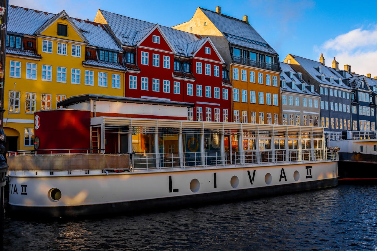 home-services-01 Vibrant buildings and canal boat at Nyhavn, Copenhagen in winter.